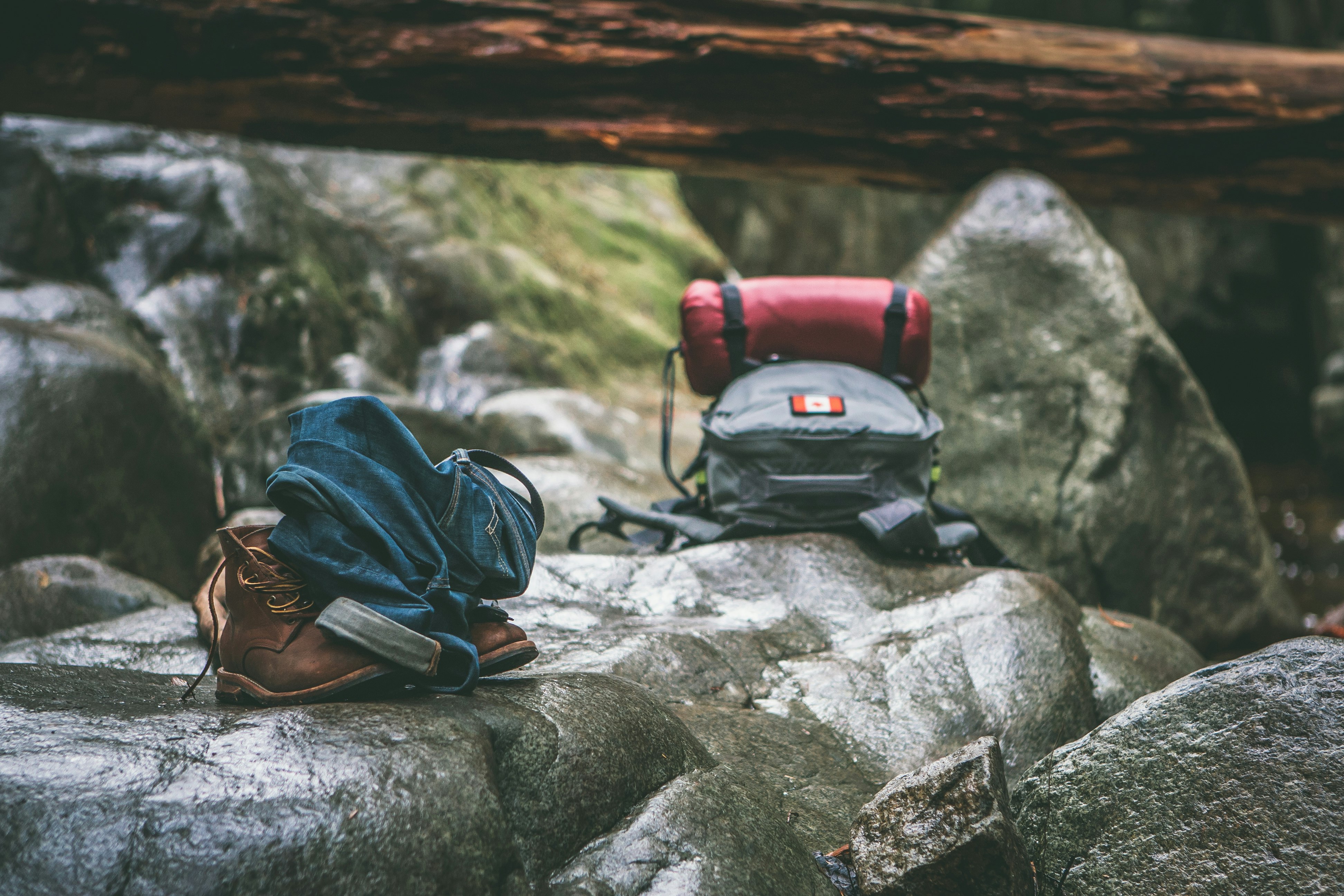 two gray and orange backpacks on gray rocks at daytime